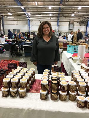Pamela Merlino at the Sassy Cat Products table of honeys at a craft show